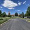 The Visitor Center is in the background under a blue sky with paved parking lot in the foreground
